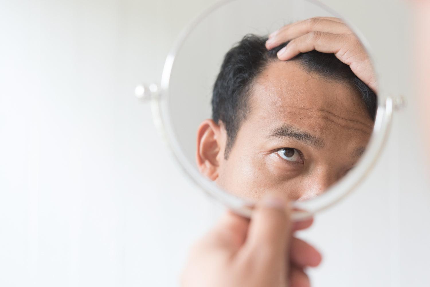 Man looking at his hair in the mirror