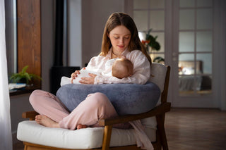 Mother and baby sitting on sofa